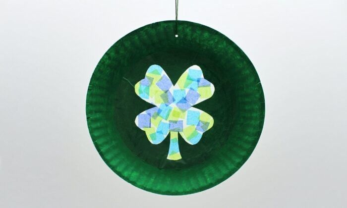 Paper plate painted green with a four leaf clover in the middle. 