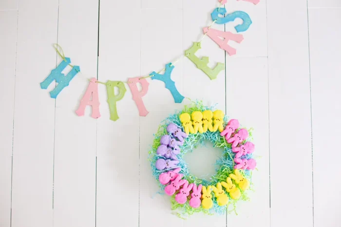 Small peep marshmallow wreath next to a sign that says Happy Easter. 