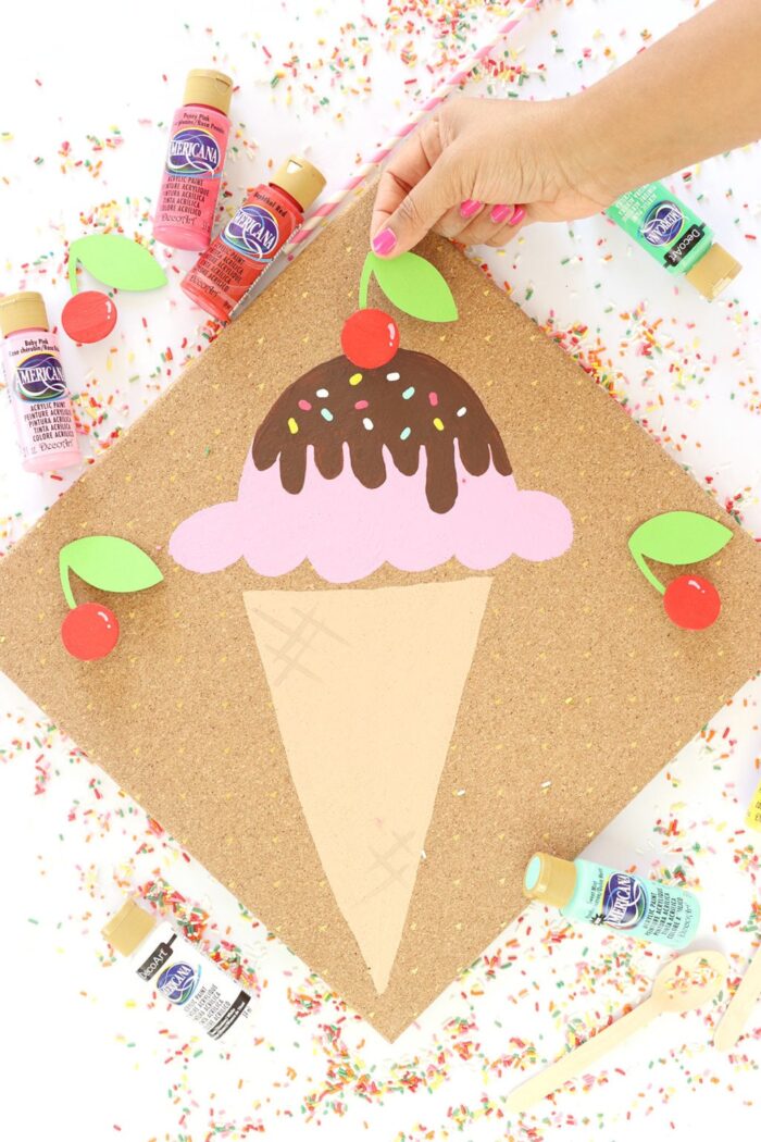 Ice Cream craft with a hand placing the cherry on top. 