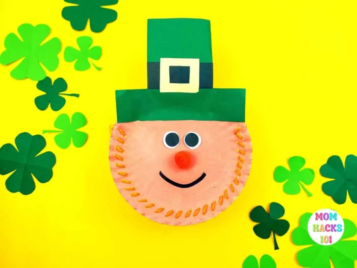 Paper plates sewn together to make a leprechaun face with a green hat. 