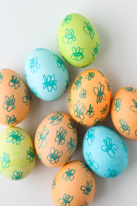 Pastel colored eggs with doodles drawn on them. 