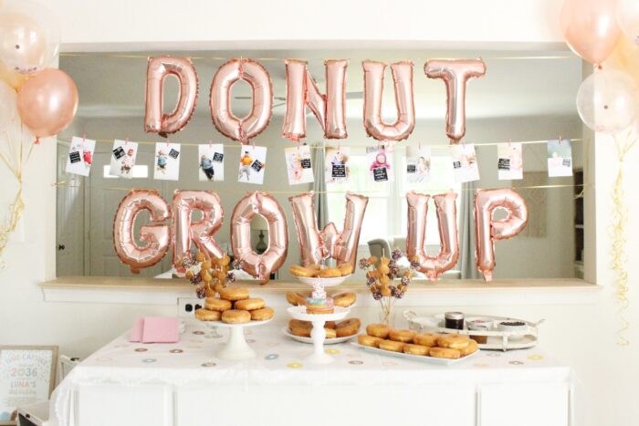 Table with donuts and balloons that say "donut grow up".