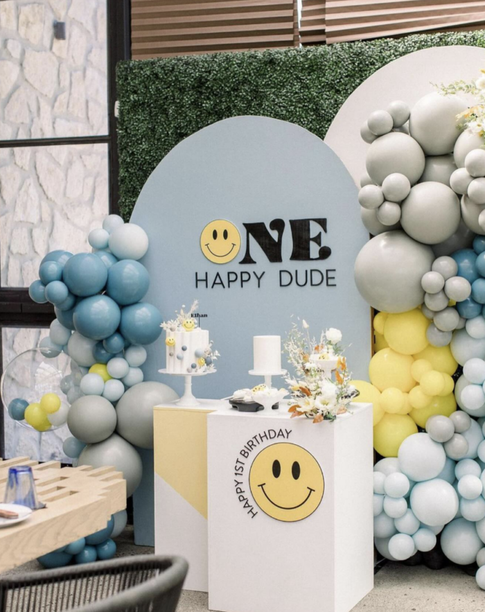 Balloons around a cake table labeled with "one happy dude".