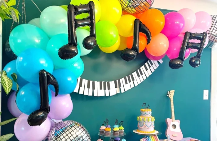 Party table with bright balloons and music note balloons. 