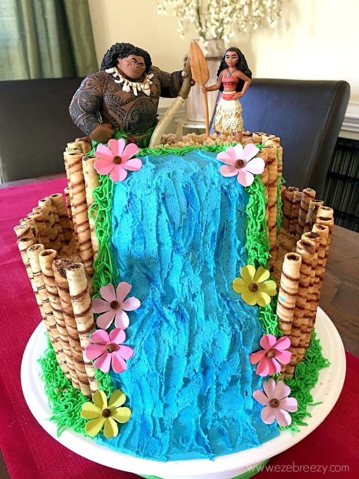 Birthday cake in the shape of a waterfall topped with Moana characters. 