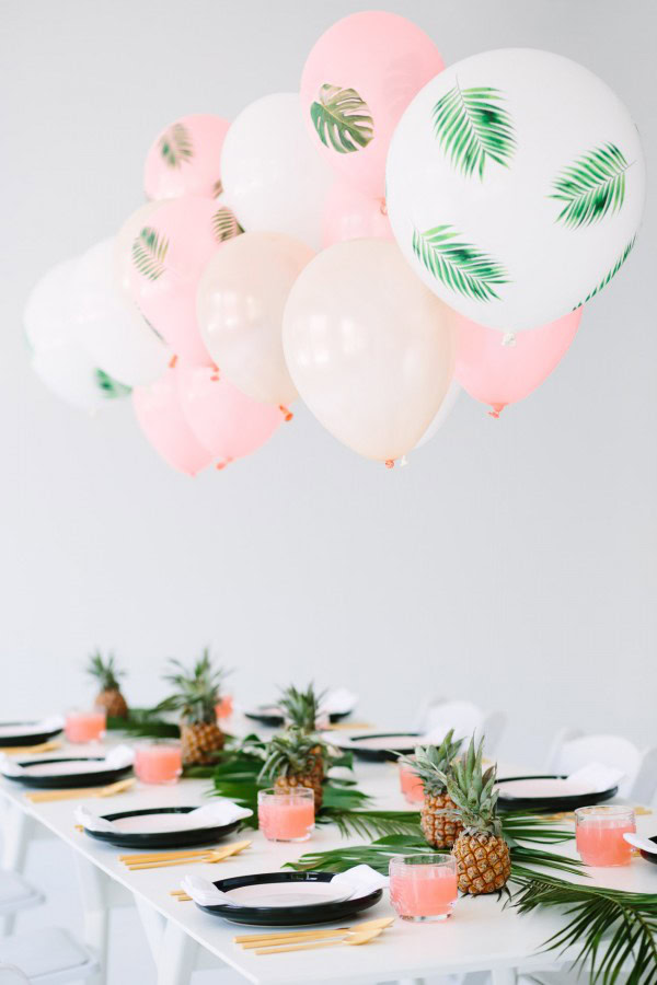 Palm frond balloons attached to a table. 