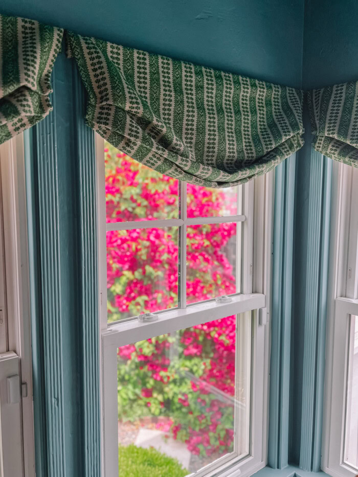 faux roman shades on windows with bougainvillea outside