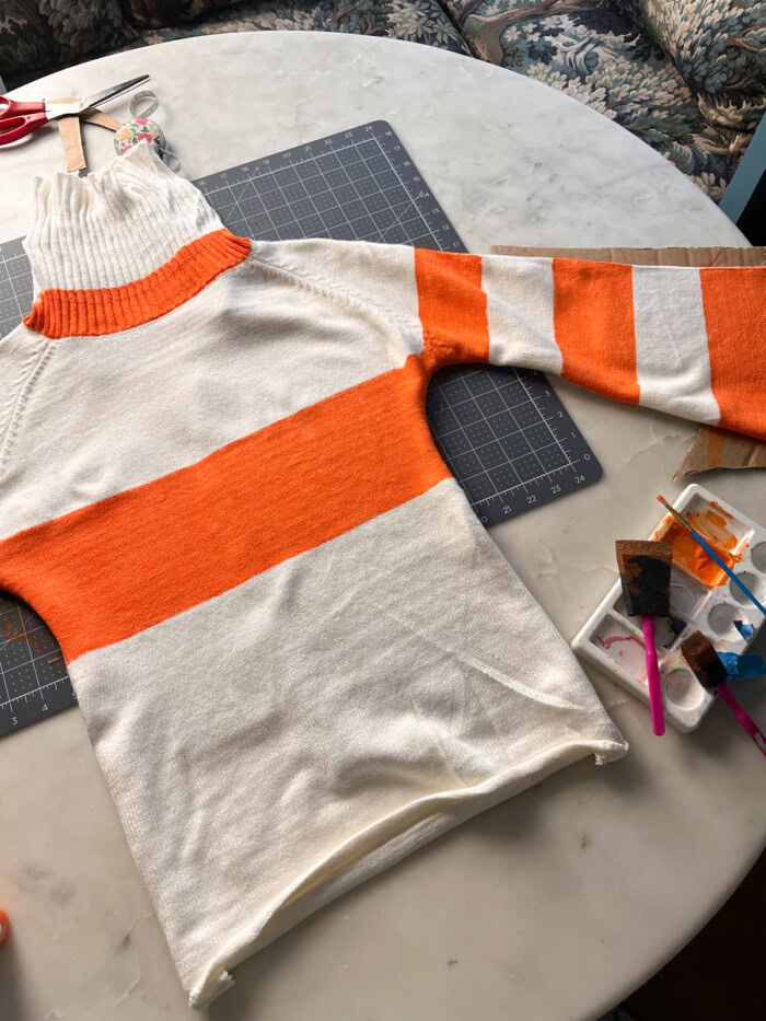 Orange stripe sweater being painted