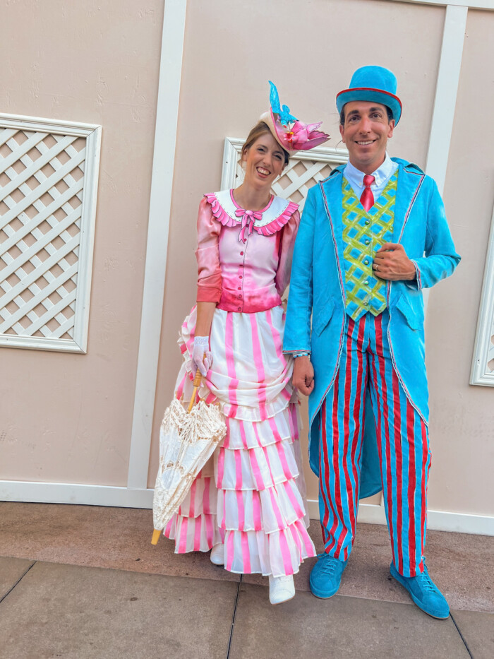 Mary Poppins Returns Costumes in front of pink wall
